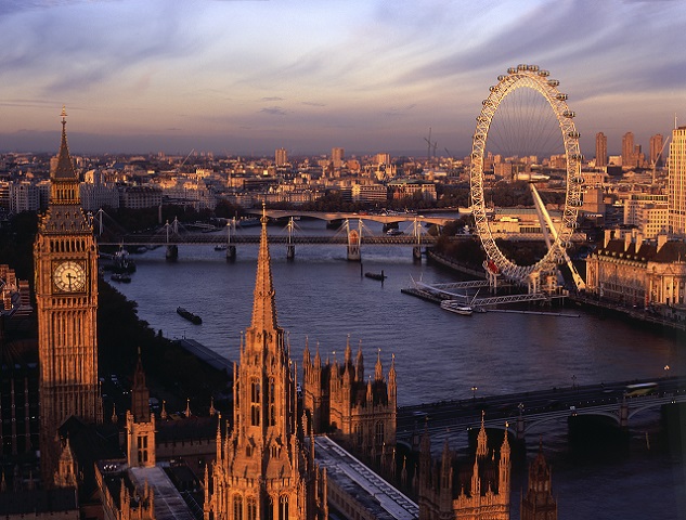View from the top of the Victoria Tower, the lesser known of the two towers of the Houses of Parliament, towards Big Ben, the River Thames and the London Eye Millennium Wheel, Westminster and the cityscape to the east. Dusk. Sunset. Britain 100.